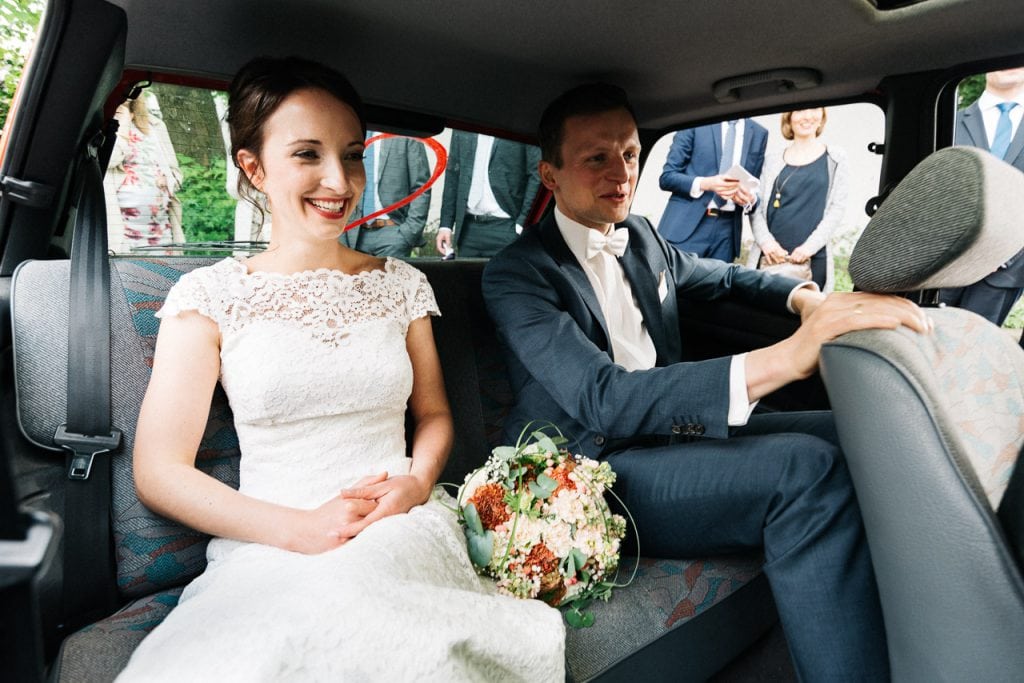 Braut und Bräutigam im Hochzeitsauto.