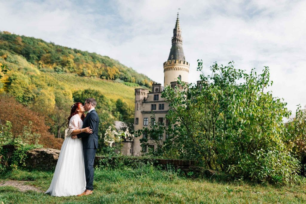 Panorama von Schloss Arenfels mit dem Brautpaar davor.