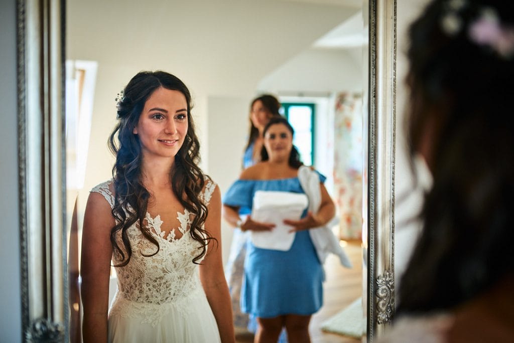 Die Braut betrachtet sich selbst im Spiegel.
