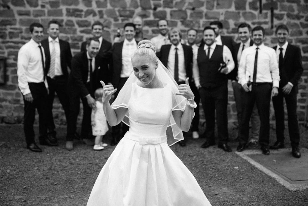 Die Braut vor einer Gruppe von Hochzeitsgästen.