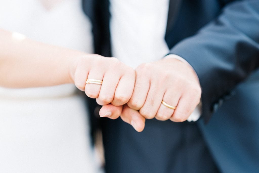 Das Brautpaar zeigt seine Ringe.