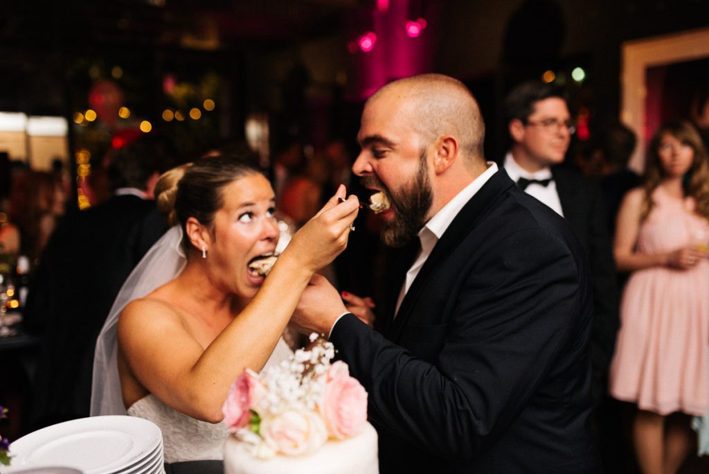 Das Brautpaar füttert sich mit Torte.
