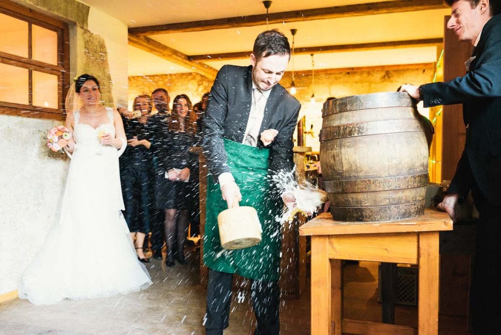 Der Bräutigam stößt ein Bierfass an.